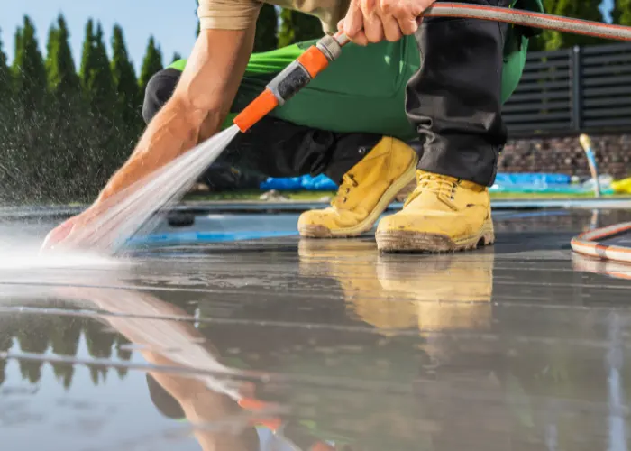 A polished concrete worker cleaning & sealing a residential concrete deck