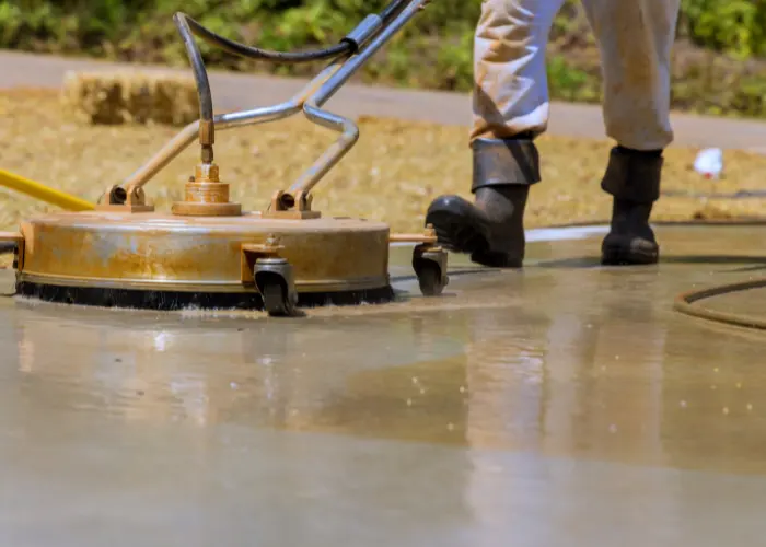 A concrete contractor cleaning a concrete driveway