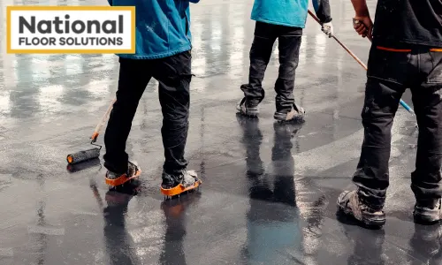 Epoxy Flooring - Image is a few concrete workers applying epoxy resign to a floor